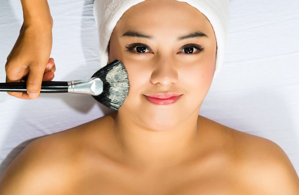 Young Asian Woman having a mask or cream applied in the course of a beauty treatment